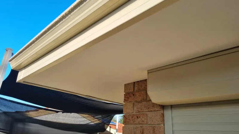 Newly installed soffit lining and guttering along a clean eave line