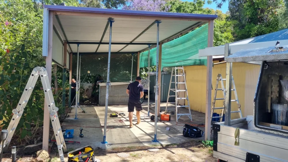 Overflow Group crew erecting the frame of a new patio and shed structure